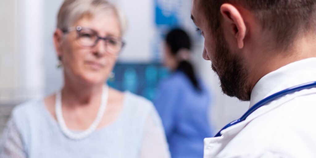 Arzt im Gespräch mit einer älteren Patientin